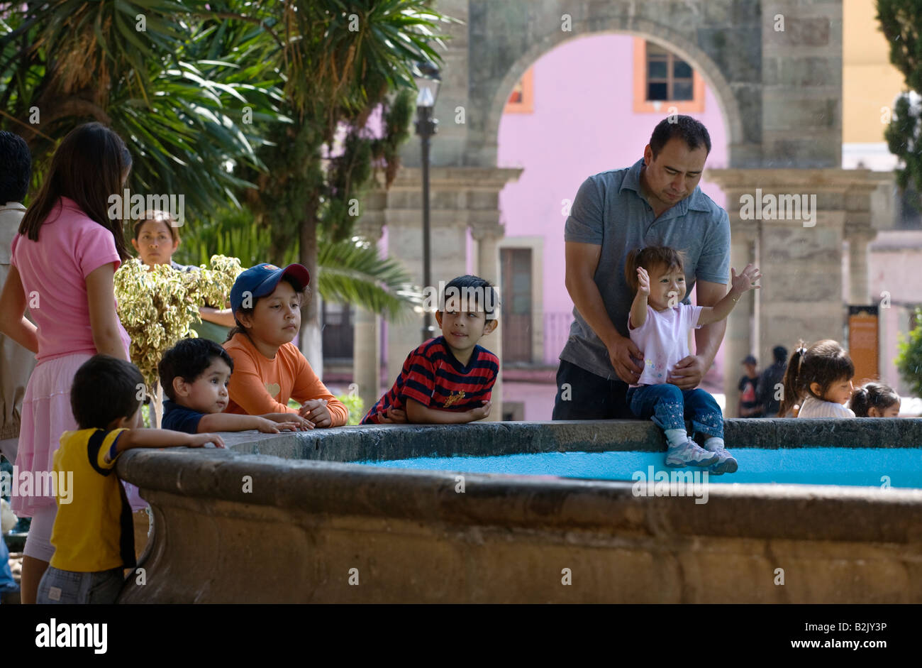 MEXICAN adulti e bambini giocare vicino a una fontana nella storica città di Guanajuato MESSICO Foto Stock