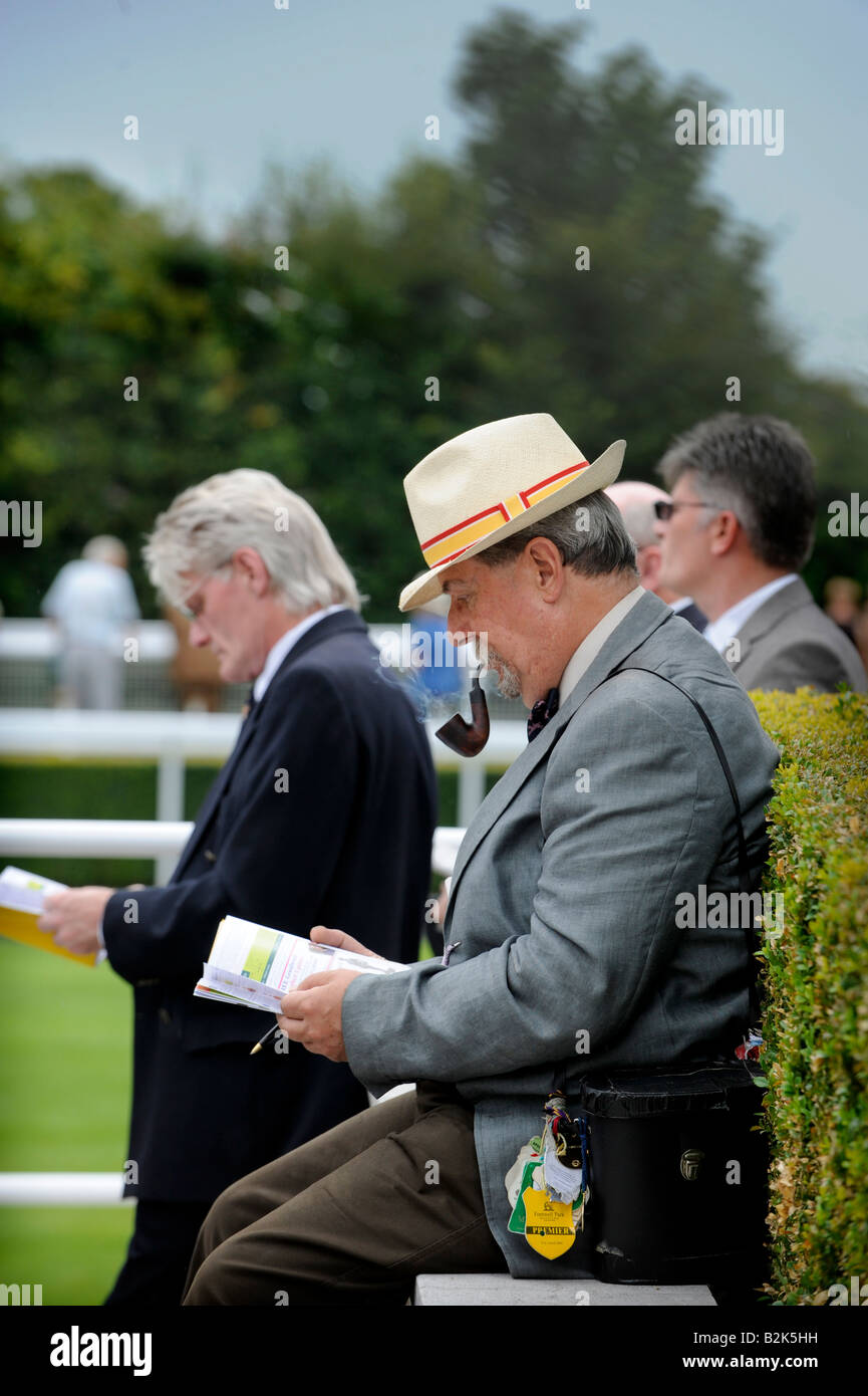 Goodwood glorioso: un vecchio gentleman di fumare un tubo e indossando il richiesto cappello di Panama il giorno delle donne. Foto Stock