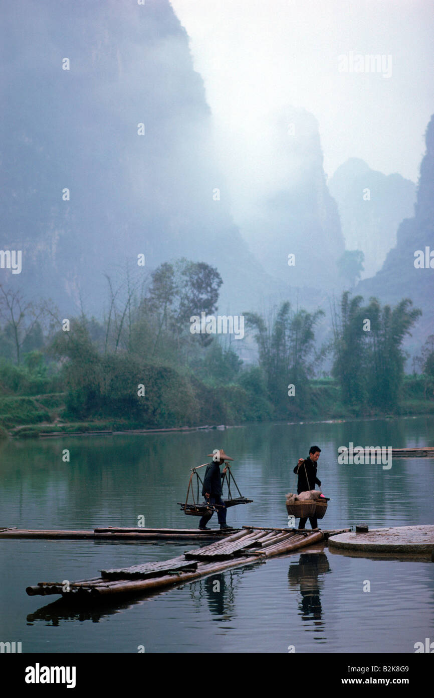 Contadini Cinesi Varcando il fiume vicino a Guilin a Yangshuo provincia di Guangxi in Cina sotto la luna picchi di montagna Foto Stock