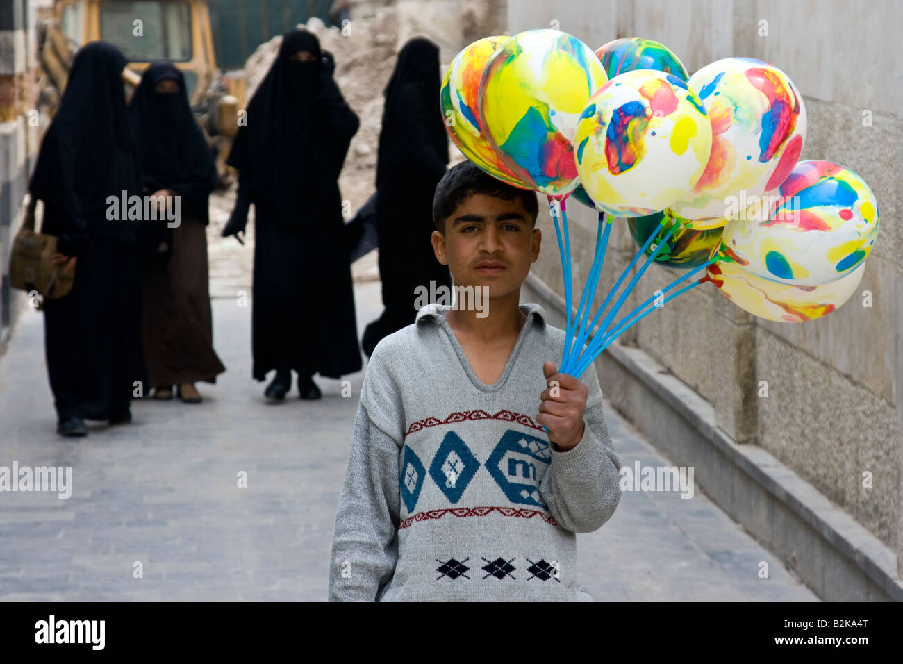 Le donne musulmane di indossare burka e ragazzo palloncini di vendita al di fuori di Umayyad moschea a Damasco in Siria Foto Stock