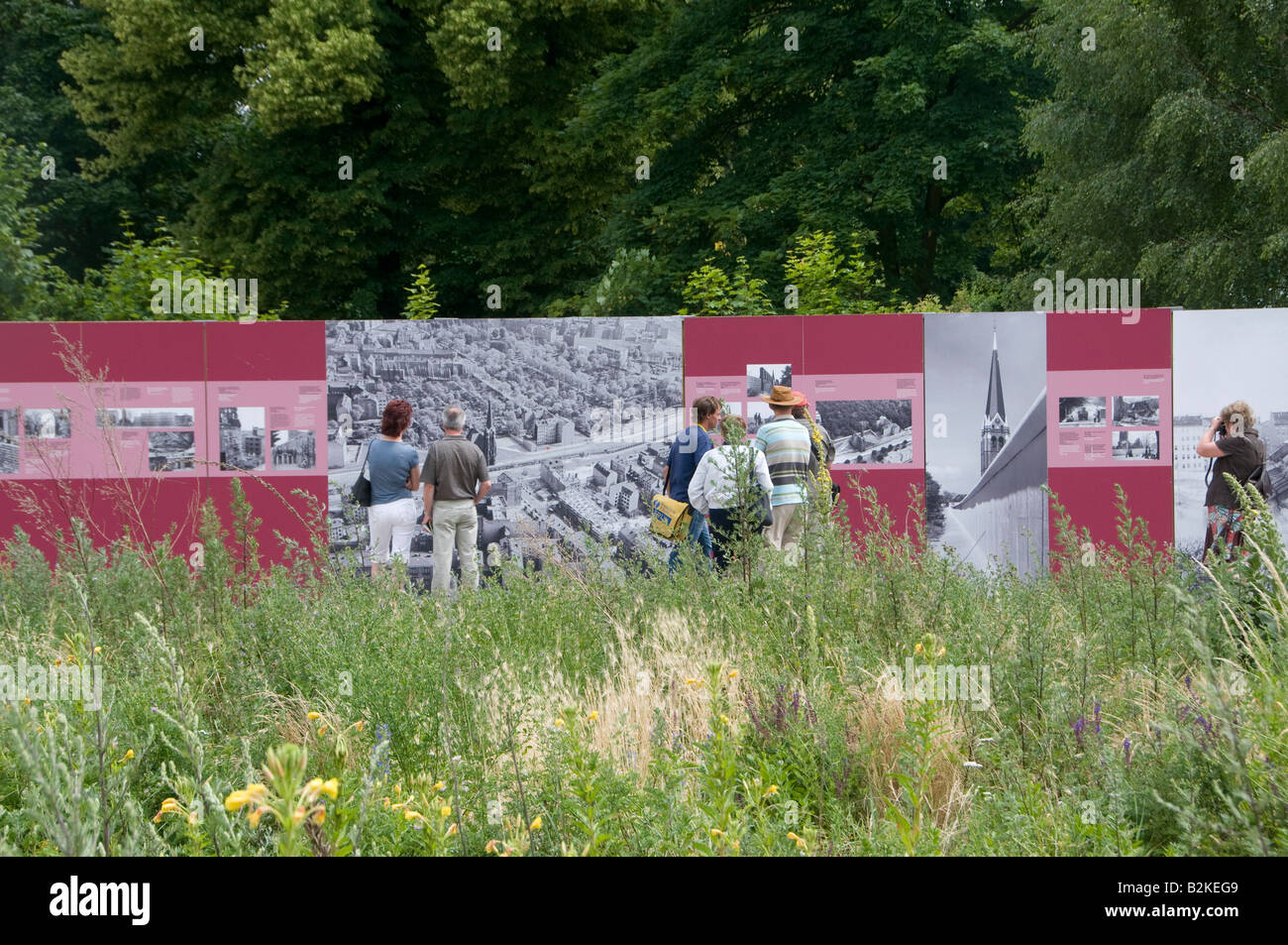 Persone che leggono manifesti storici in corrispondenza della posizione in cui la parete divisa fra est e ovest. Quartiere Tiergarten di Berlino Germania Foto Stock