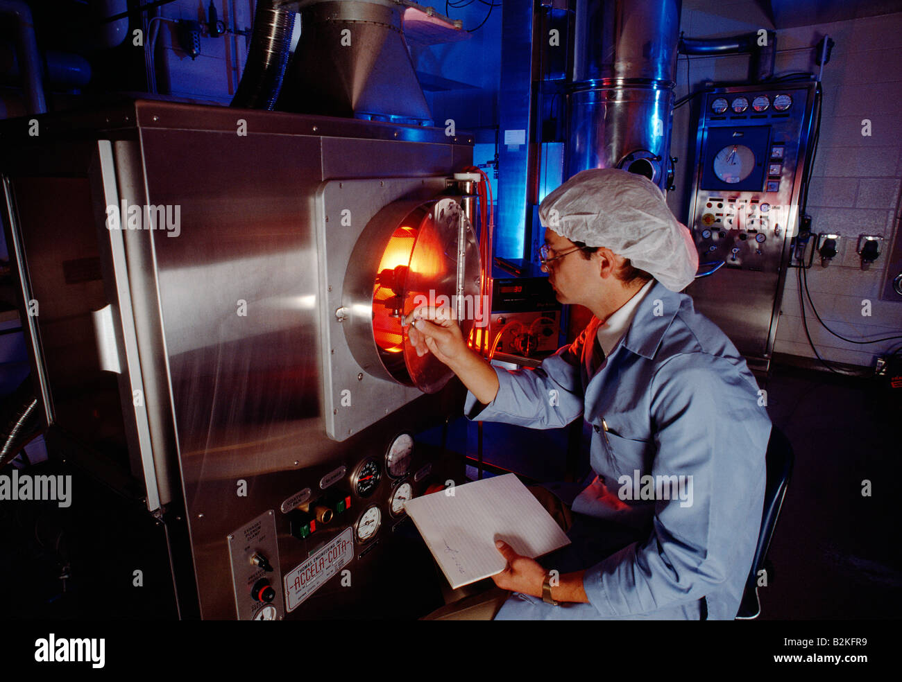 Scienziato che accede a un forno nel laboratorio di ricerca di una società farmaceutica Foto Stock