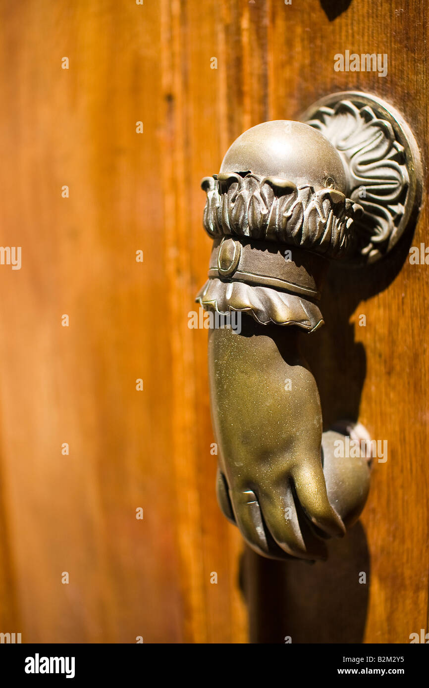 In ottone a forma di mano porta respingente sulla porta di legno in Francia Foto Stock
