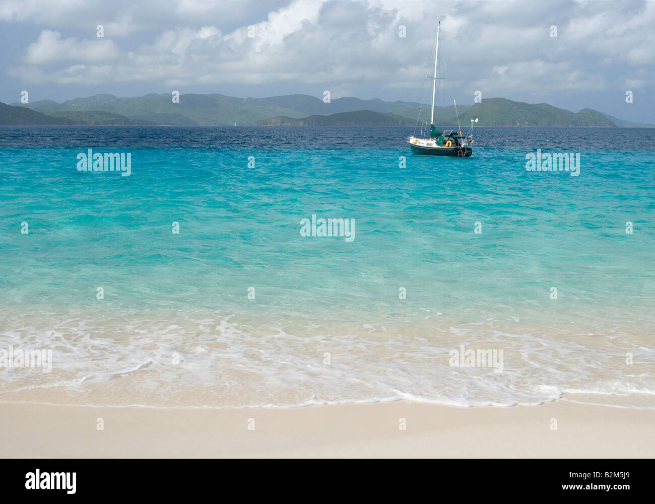 Una crociera in barca a vela ancorata accanto a Sandy Cay nelle Isole Vergini Britanniche San Giovanni è visibile in background Foto Stock