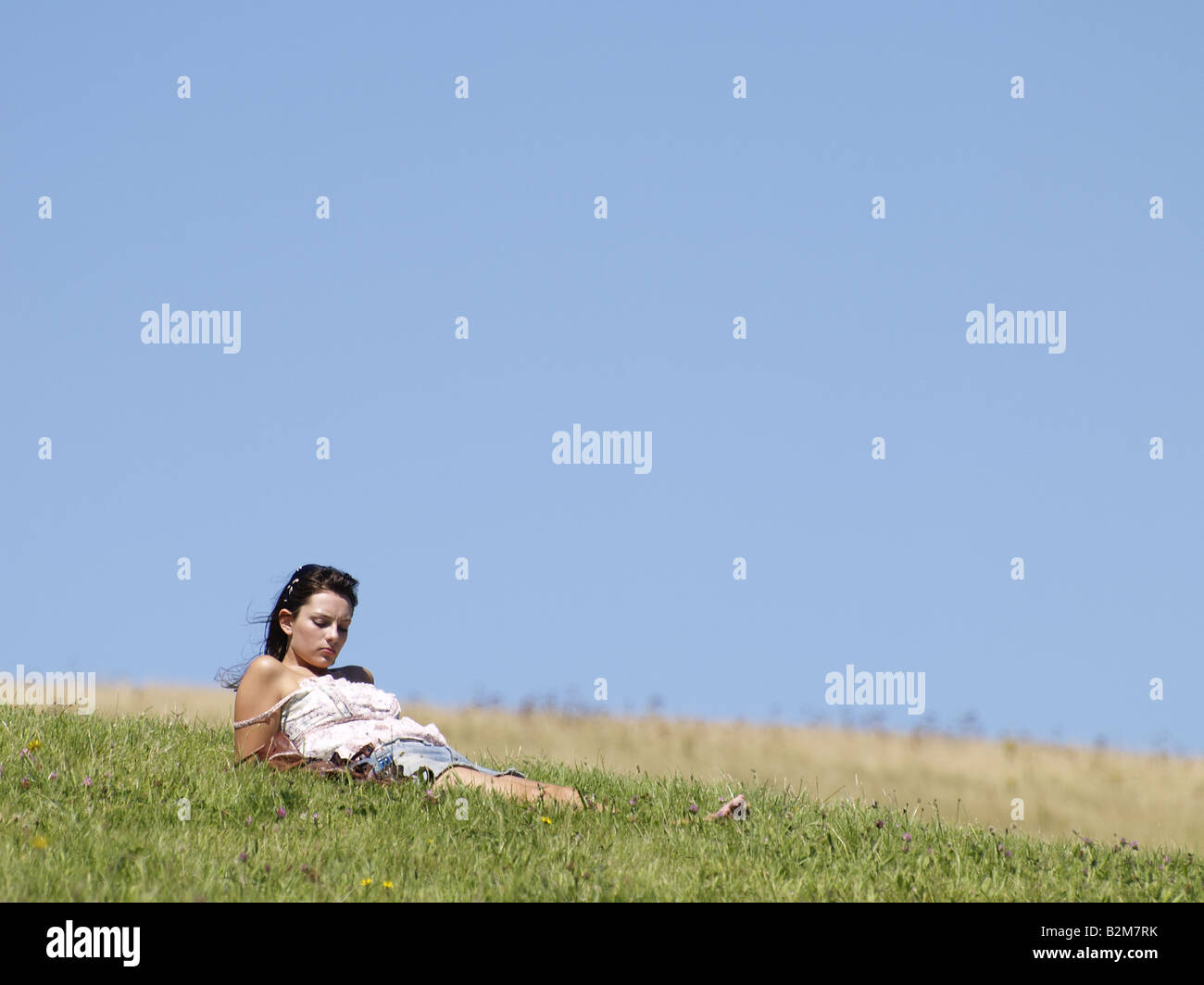 Giovane donna a prendere il sole su una coperta di erba hill Foto Stock