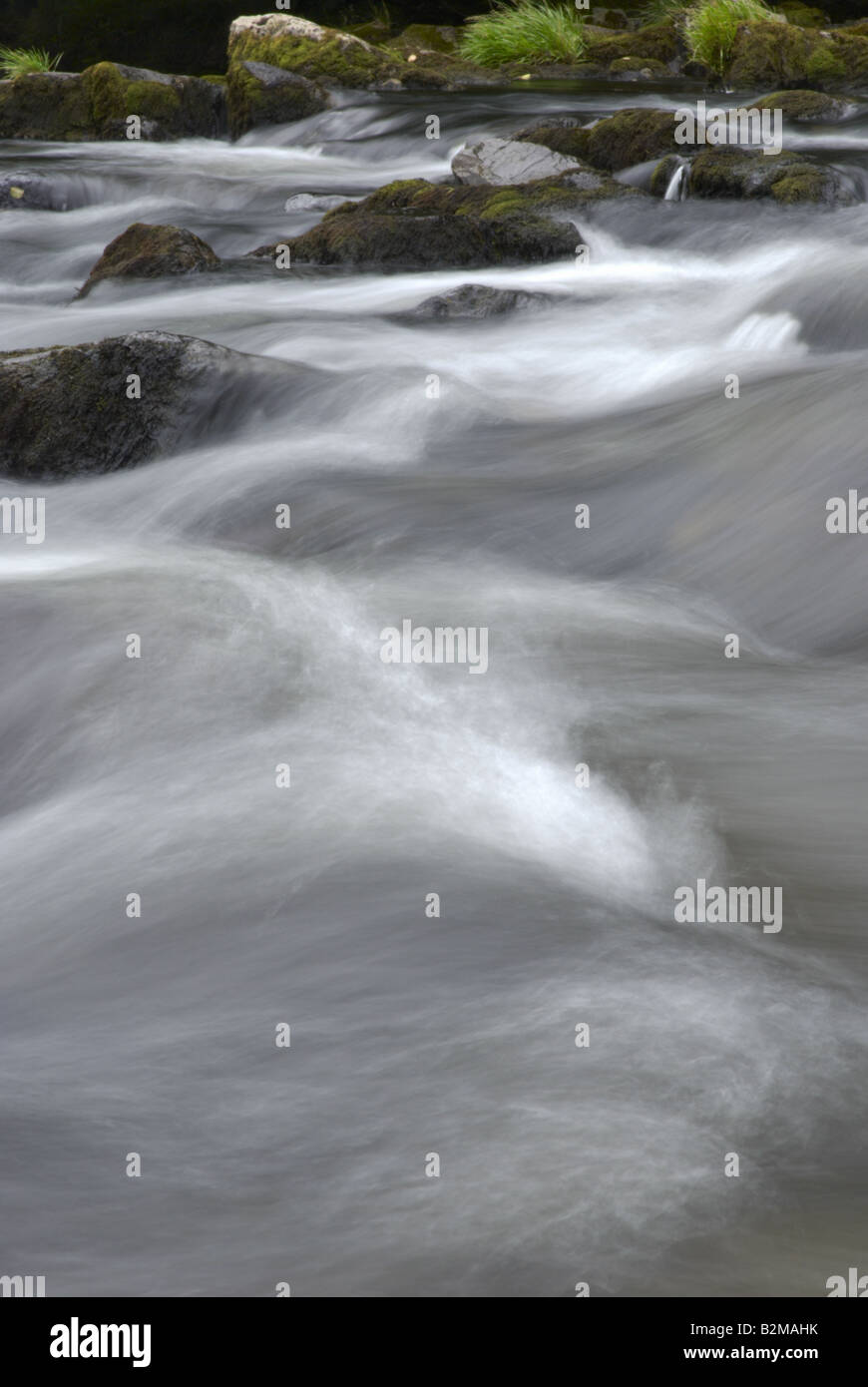 In rapido movimento di acqua di un fiume che scorre sulle pietre in una serie di rapide Foto Stock