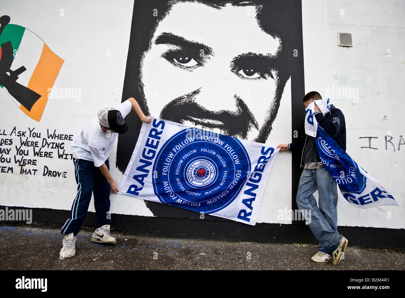 Rangers Football Supporters con il loro banner, pongono di fronte a un murale nel quartiere bogside, Derry, Irlanda del Nord Foto Stock