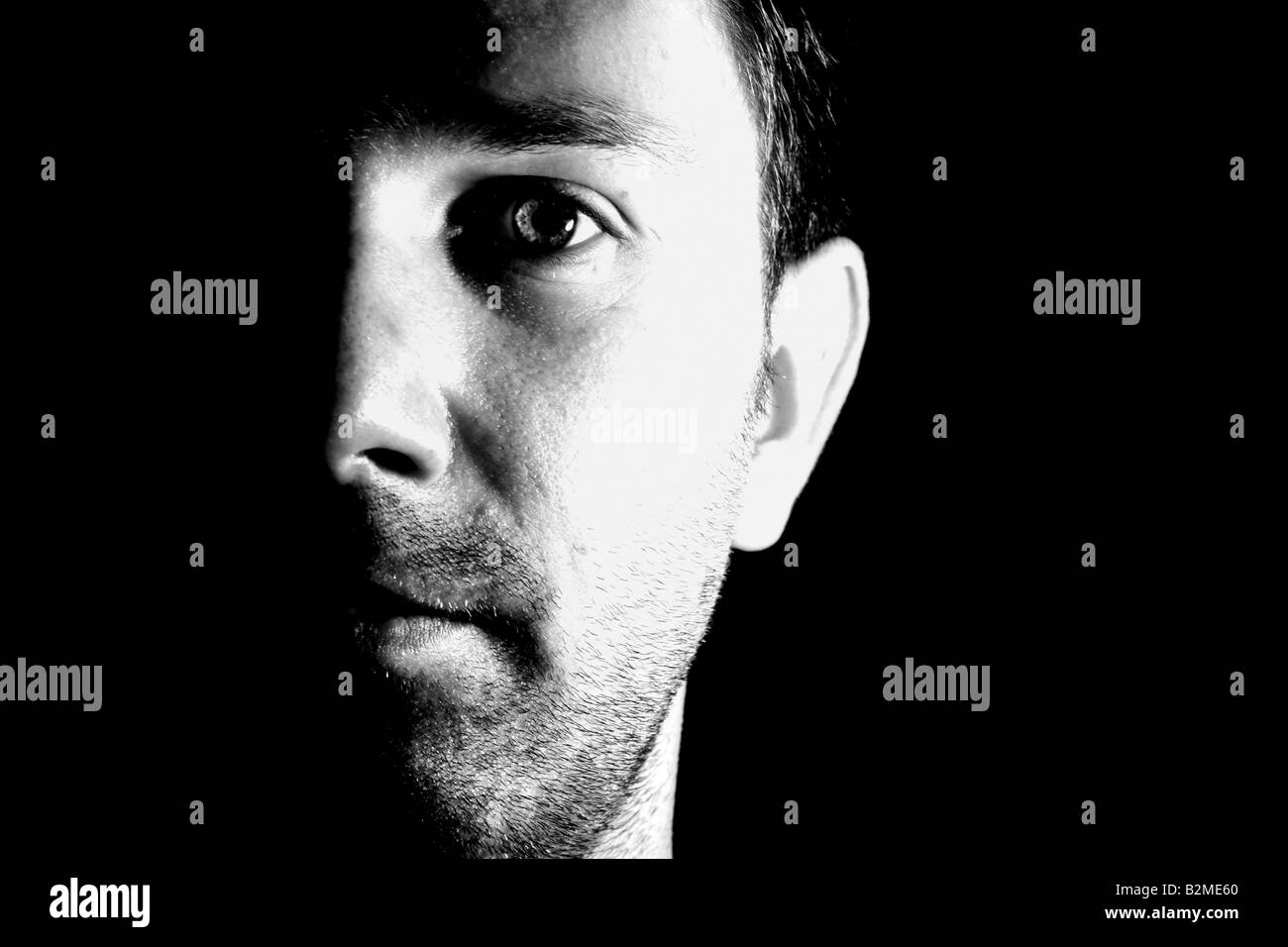 Stark un ritratto in bianco e nero di un uomo caucasico del volto, metà in ombra Foto Stock