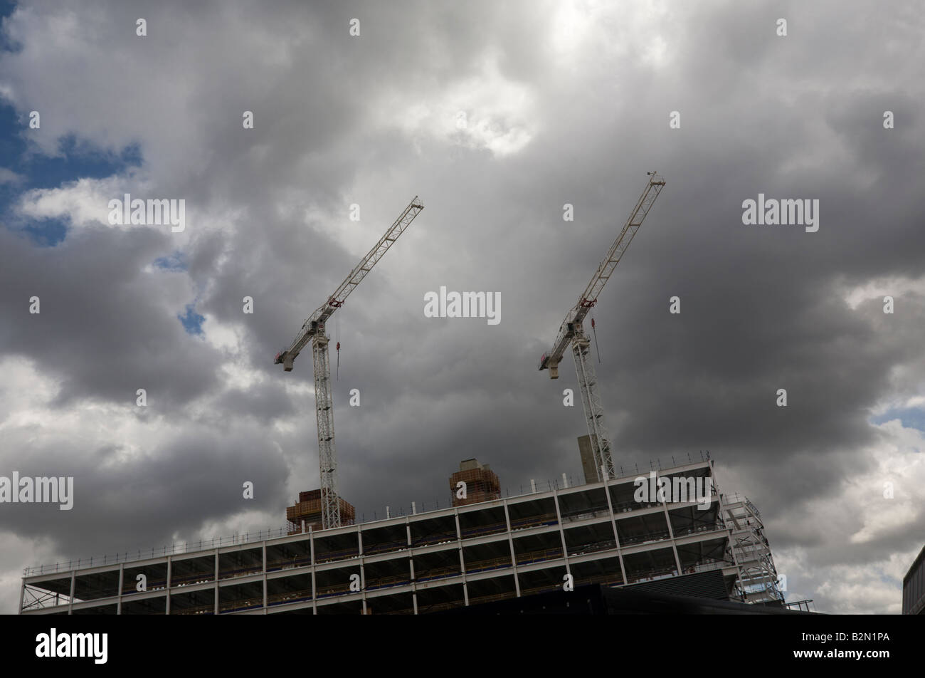 Gru edili contro un grigio scuro cielo velato Foto Stock