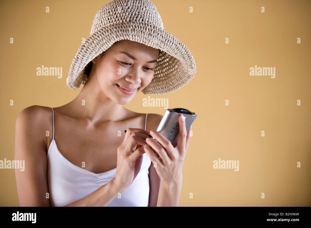Close-up di una giovane donna che utilizza un assistente di dati personale e smirking Foto Stock