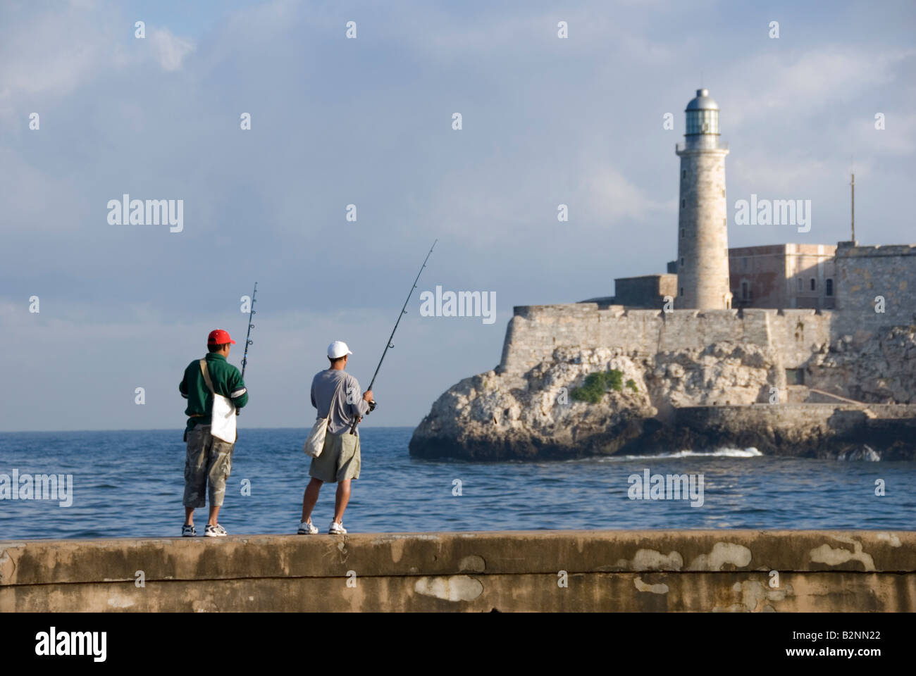 Gli uomini la pesca di fronte al faro di Morro Castle Havana Cuba Foto Stock