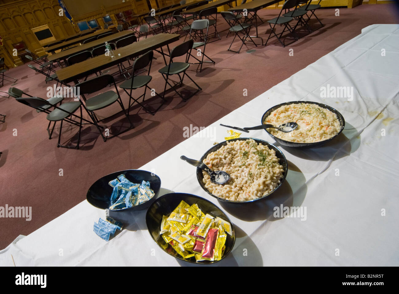 Uneaten prodotti alimentari e a condimenti su un tavolo in un vuoto di sala riunioni Foto Stock