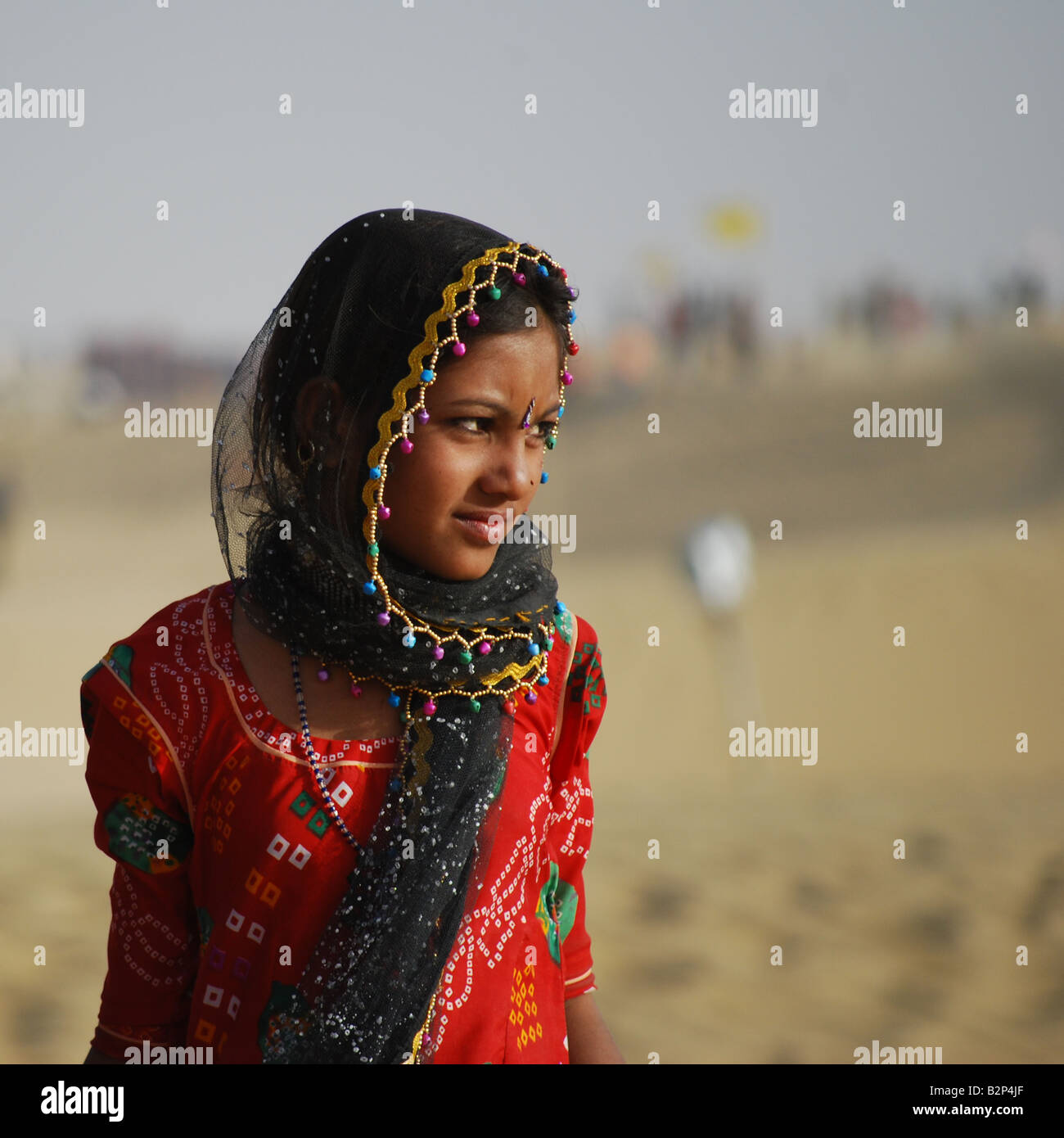 Una giovane donna indiana in un colorato abbigliamento tradizionale presso il Festival del cammello nel Grande deserto di Thar, Jaisalmer, India. Foto Stock