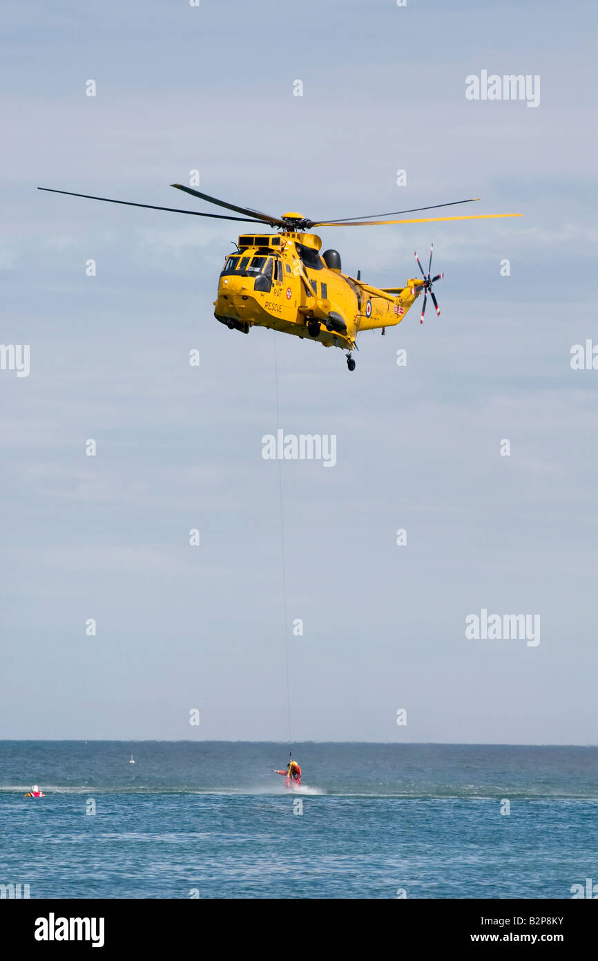 La RAF Sea King Salvataggio in elicottero con winchman distribuito il recupero del superstite dal mare Foto Stock