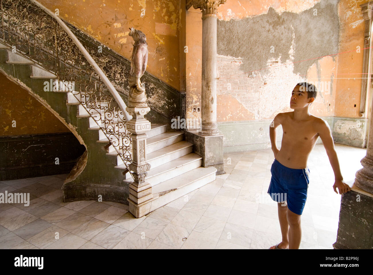Adolescente guardando verso l'alto scalone interno corrono verso casa coloniale utilizzato nel film cubano Fresa y Chocolate. Centro, Havana Foto Stock