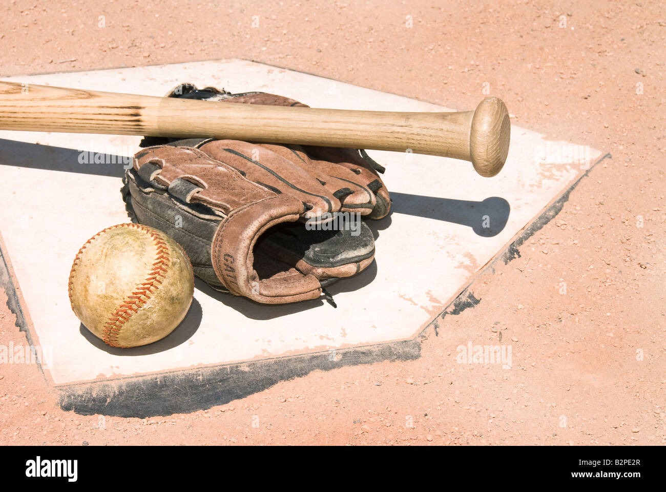 Una mazza da baseball guanto e la sfera si trovano sulla parte superiore della piastra di casa come un concettuale immagine sportiva Foto Stock
