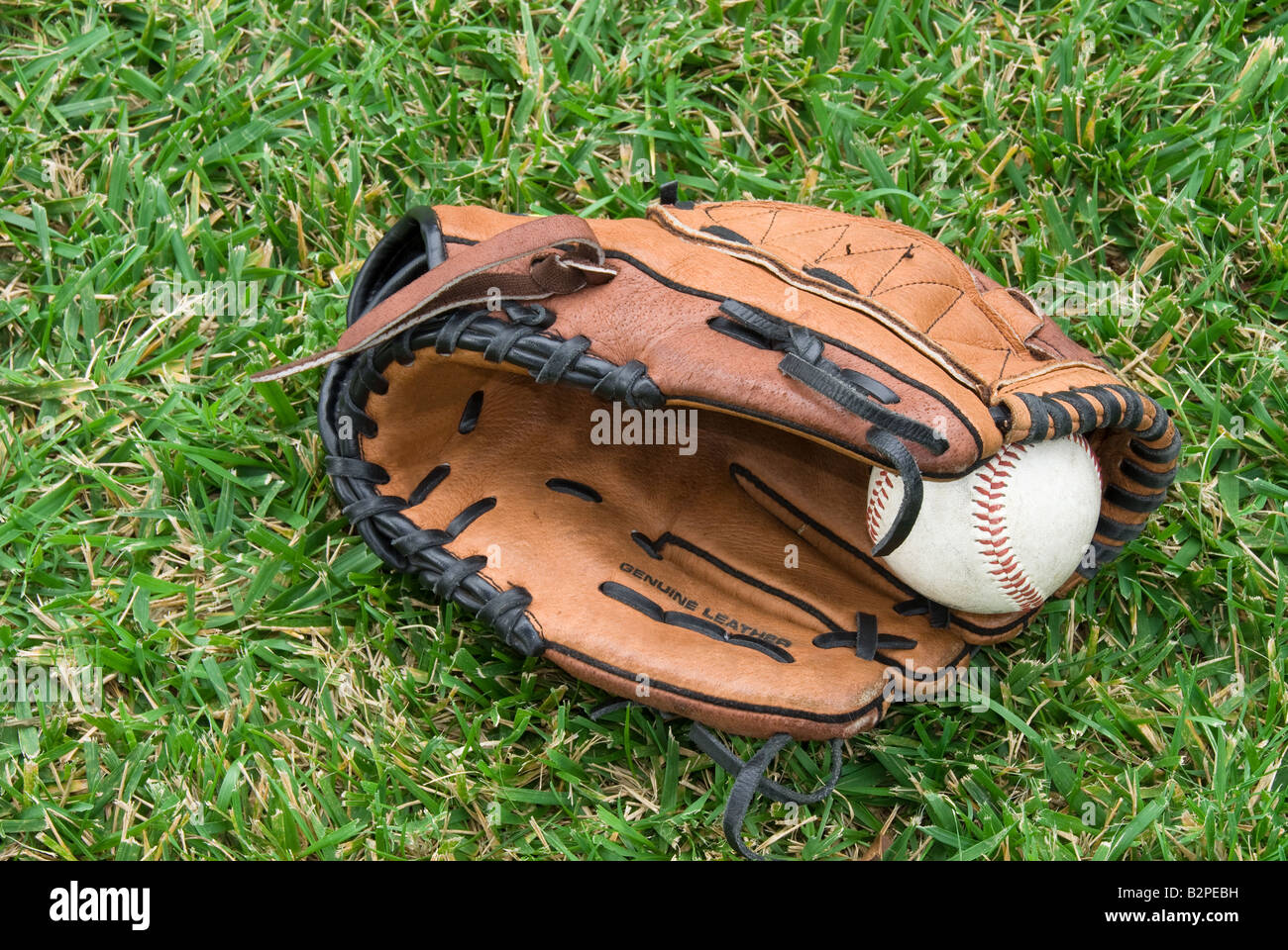 Un guanto da baseball e la sfera si trovano in erba prima di un gioco Foto Stock