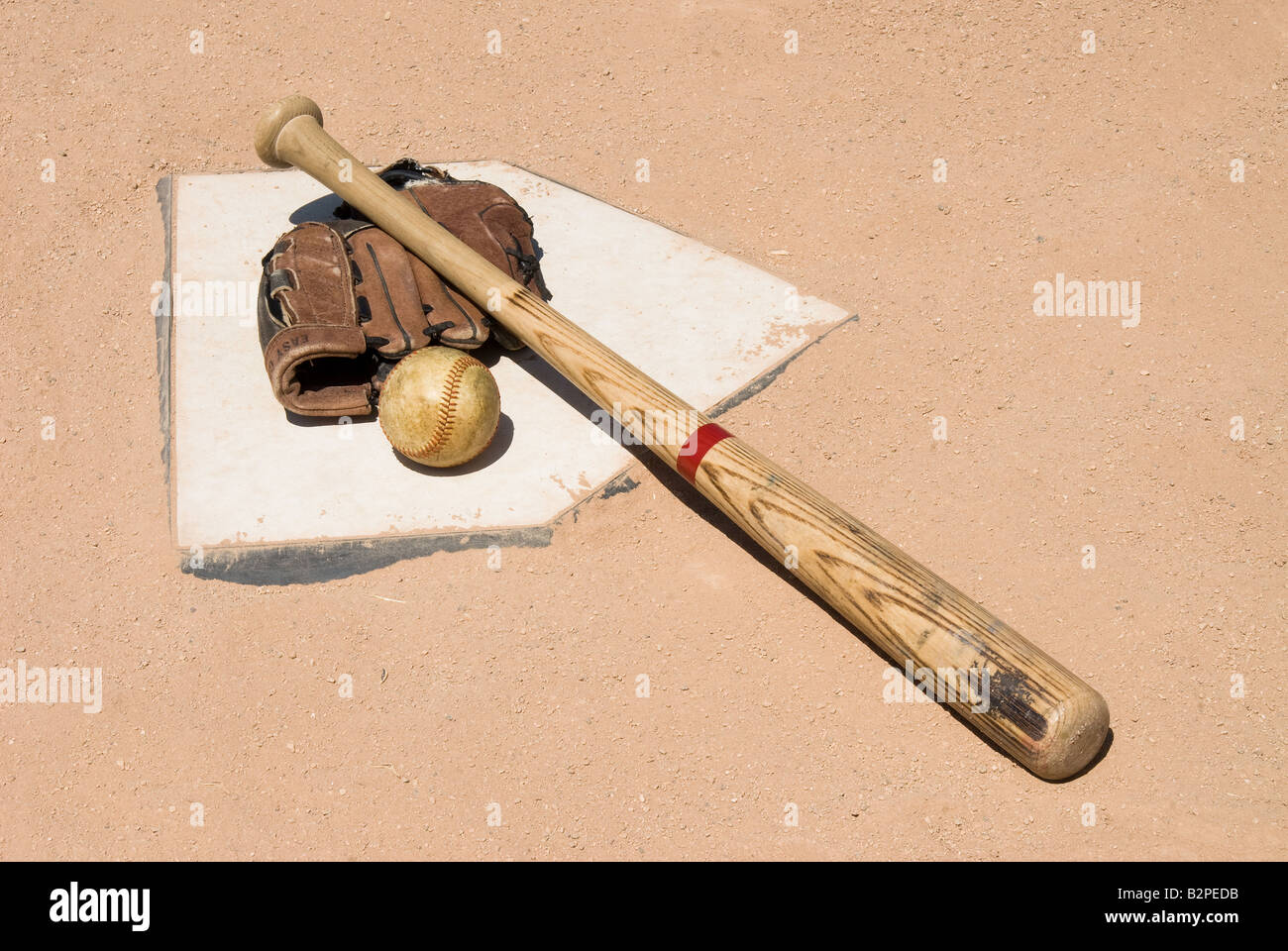 Attrezzatura da baseball seduti sulla piastra iniziale impostato come una immagine concettuale Foto Stock