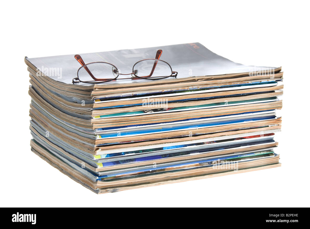 Una pila di vecchie riviste usurati isolata contro uno sfondo bianco Foto Stock