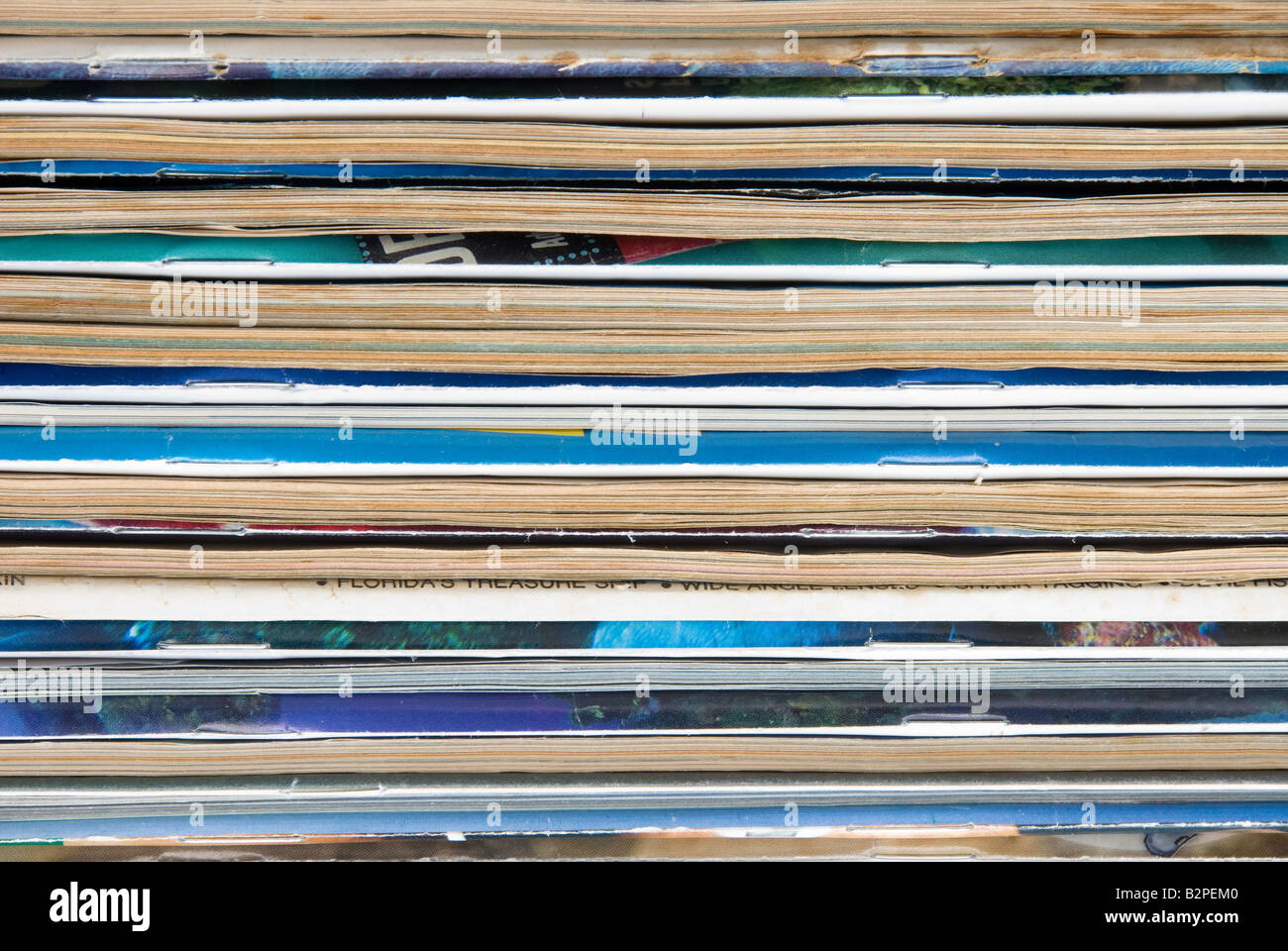 Una pila di vecchie riviste usurati isolata contro uno sfondo bianco Foto Stock