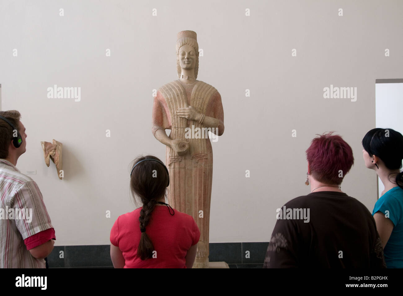 I visitatori che desiderano in greco antico reliquia e di indossare le cuffie per audio guida tour del sistema Nel Pergamon Museum in Museumsinsel isola Berlino Germania Foto Stock