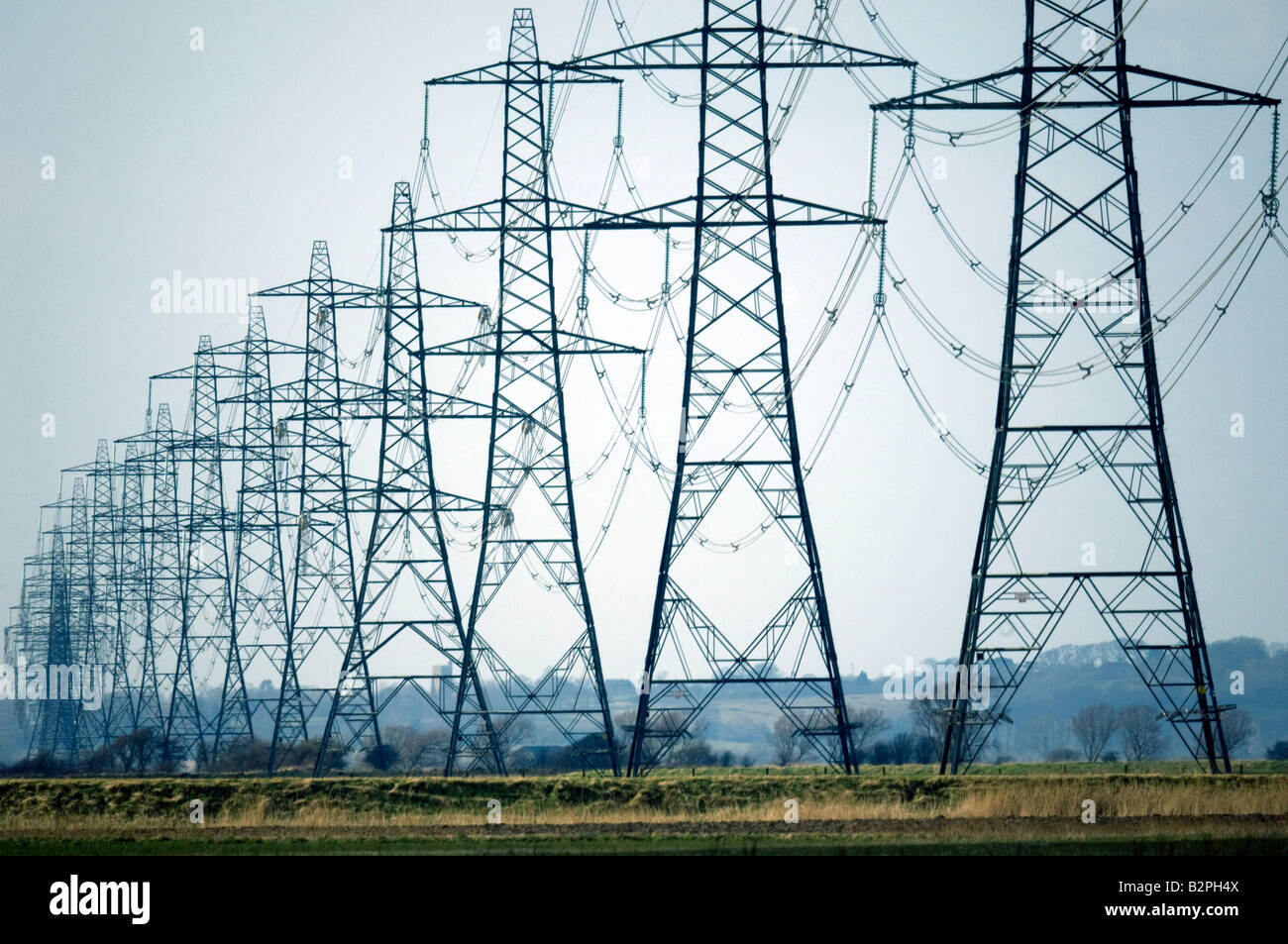 Tralicci di energia elettrica Potenza di trasporto da parte di British Energy Dungeness B Centrale Nucleare attraverso la campagna del Kent Foto Stock