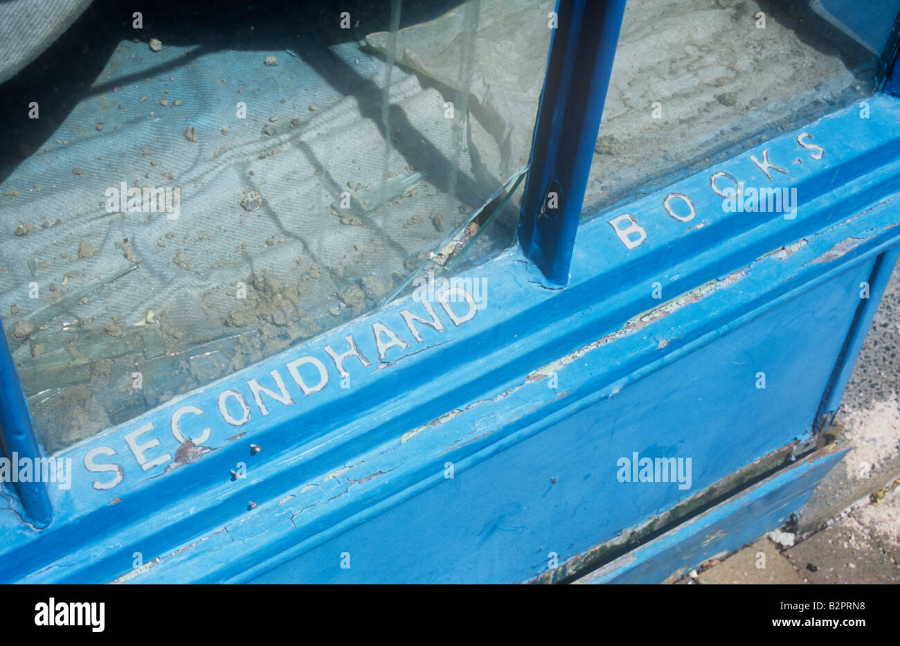 Una volta elegante negozio finestra blu con telaio in legno ora abbandonata con lettere bloccato sul telaio ma affermando di pelatura di Seconda Mano Libri Foto Stock
