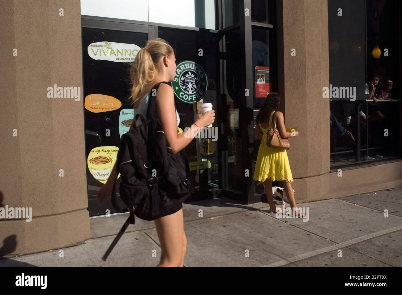 I clienti al di fuori di un Starbucks Coffeehouse in nel quartiere di Chelsea di New York Foto Stock