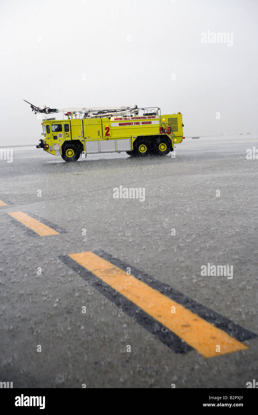 Le attrezzature di emergenza sull'asfalto durante un acquazzone presso l'Aeroporto Internazionale Logan di Boston, Massachusetts Foto Stock