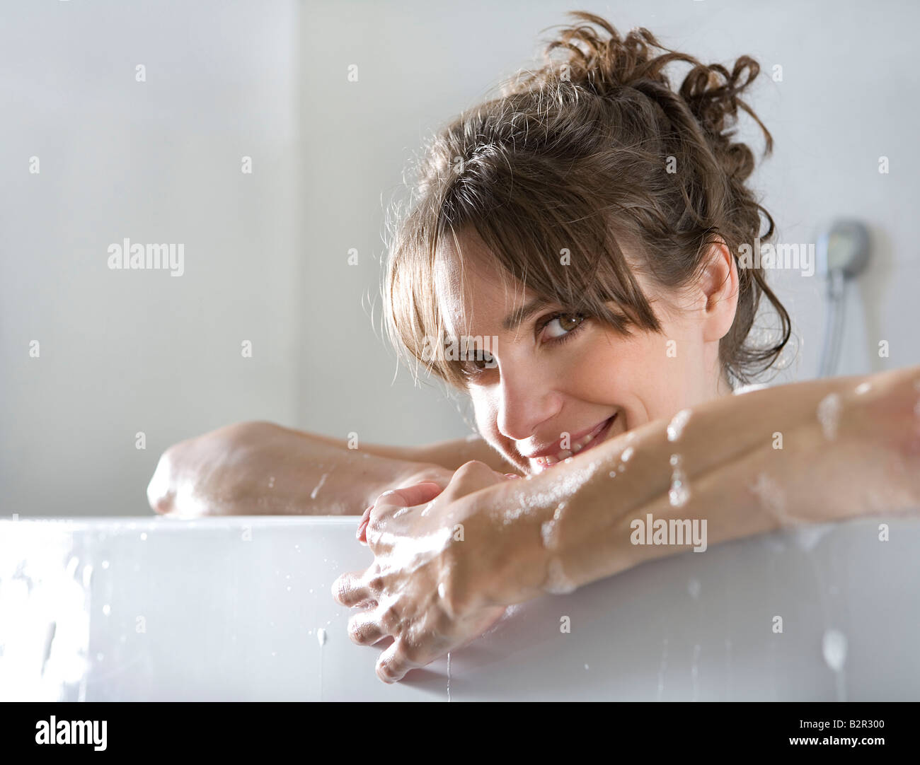 La donna nella vasca da bagno, sorridente Foto Stock