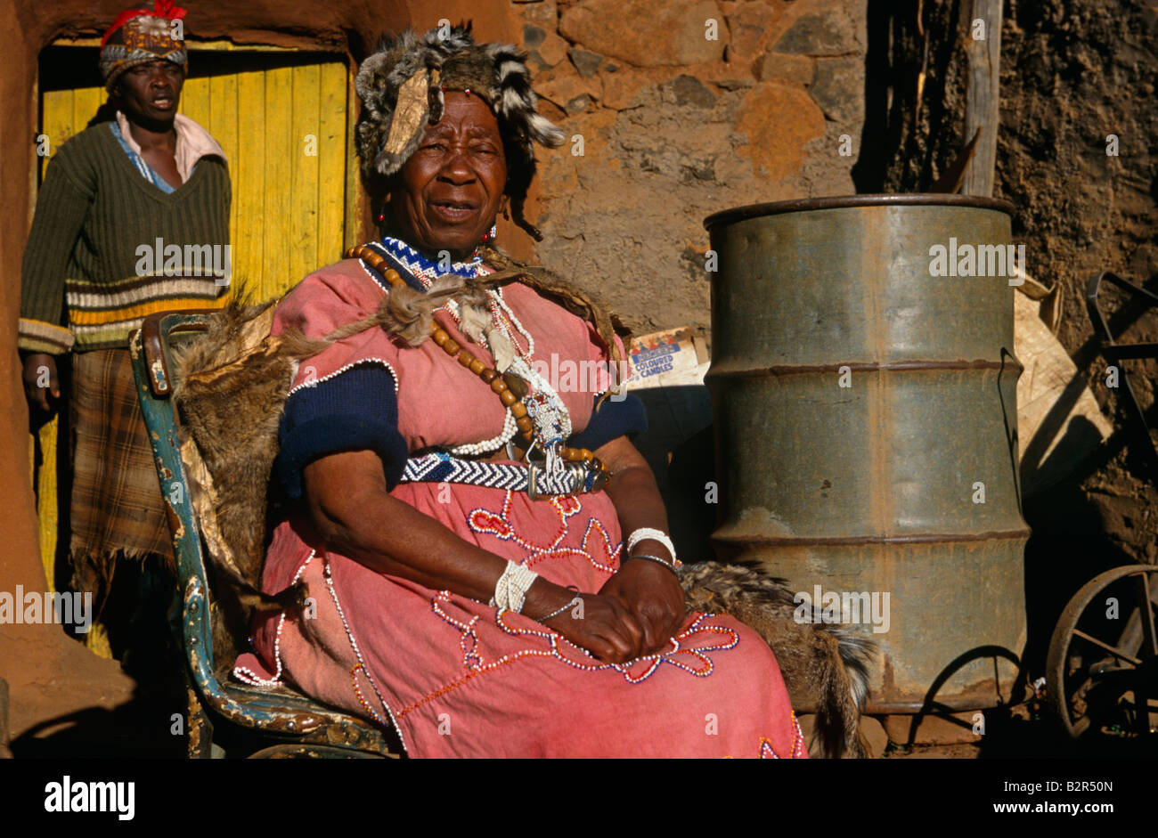 Sangoma (guaritore tradizionale) seduto davanti a casa, Lesotho, Africa Foto Stock