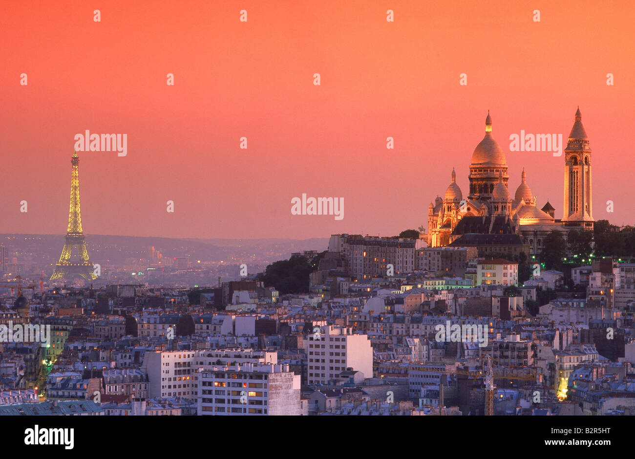 Il Sacro Cuore e la Torre Eiffel al di sopra dello skyline di Parigi al crepuscolo Foto Stock
