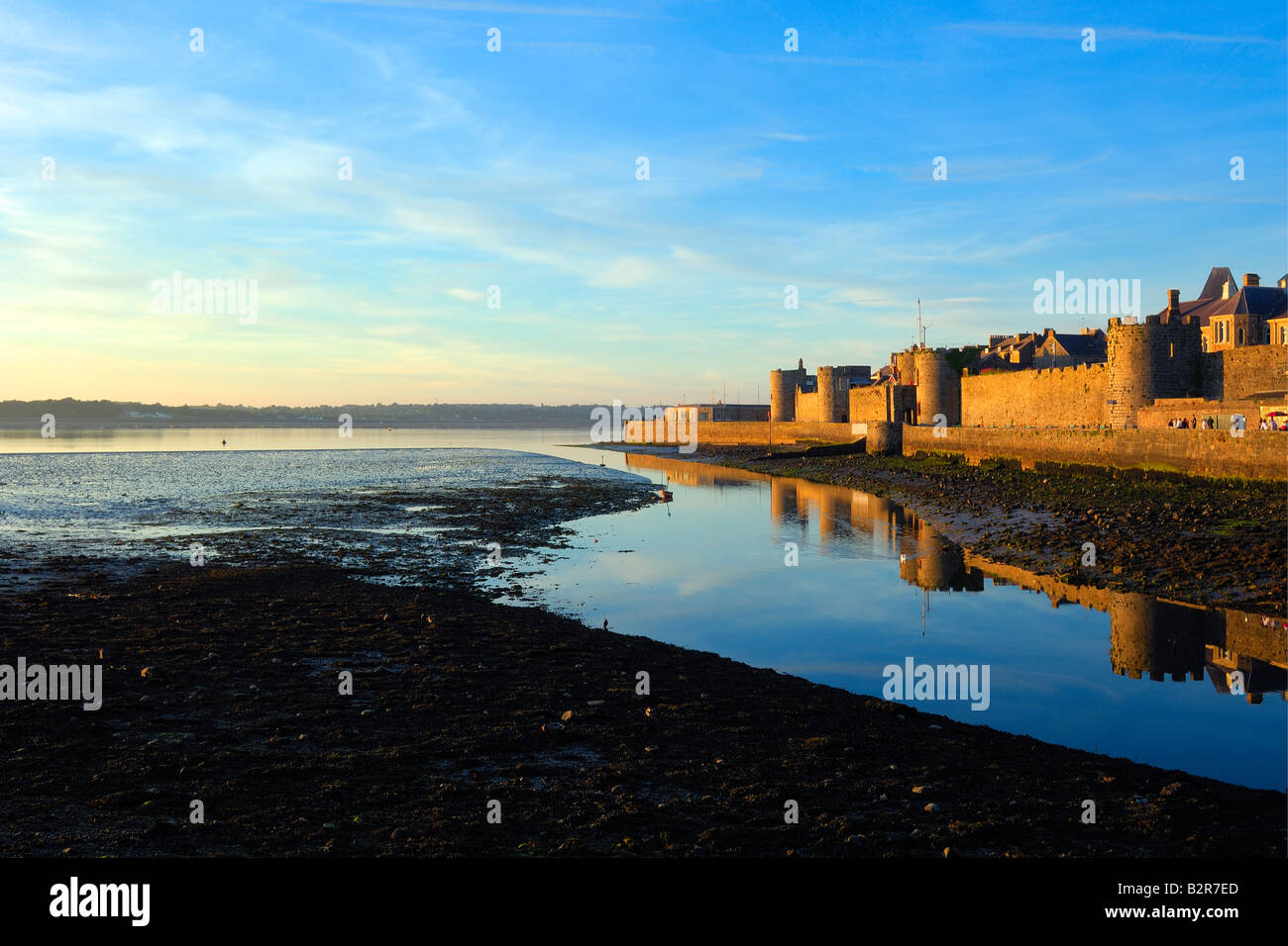Le pareti esterne del Caernarfon Castle sulla costa del Galles del Nord in tarda serata sole Foto Stock