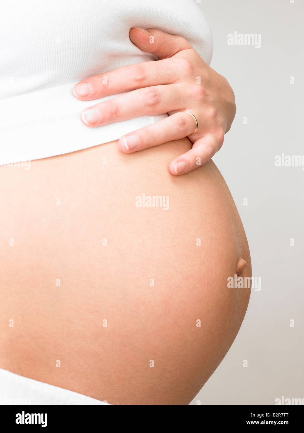 Donna incinta toccando il suo ventre Foto Stock
