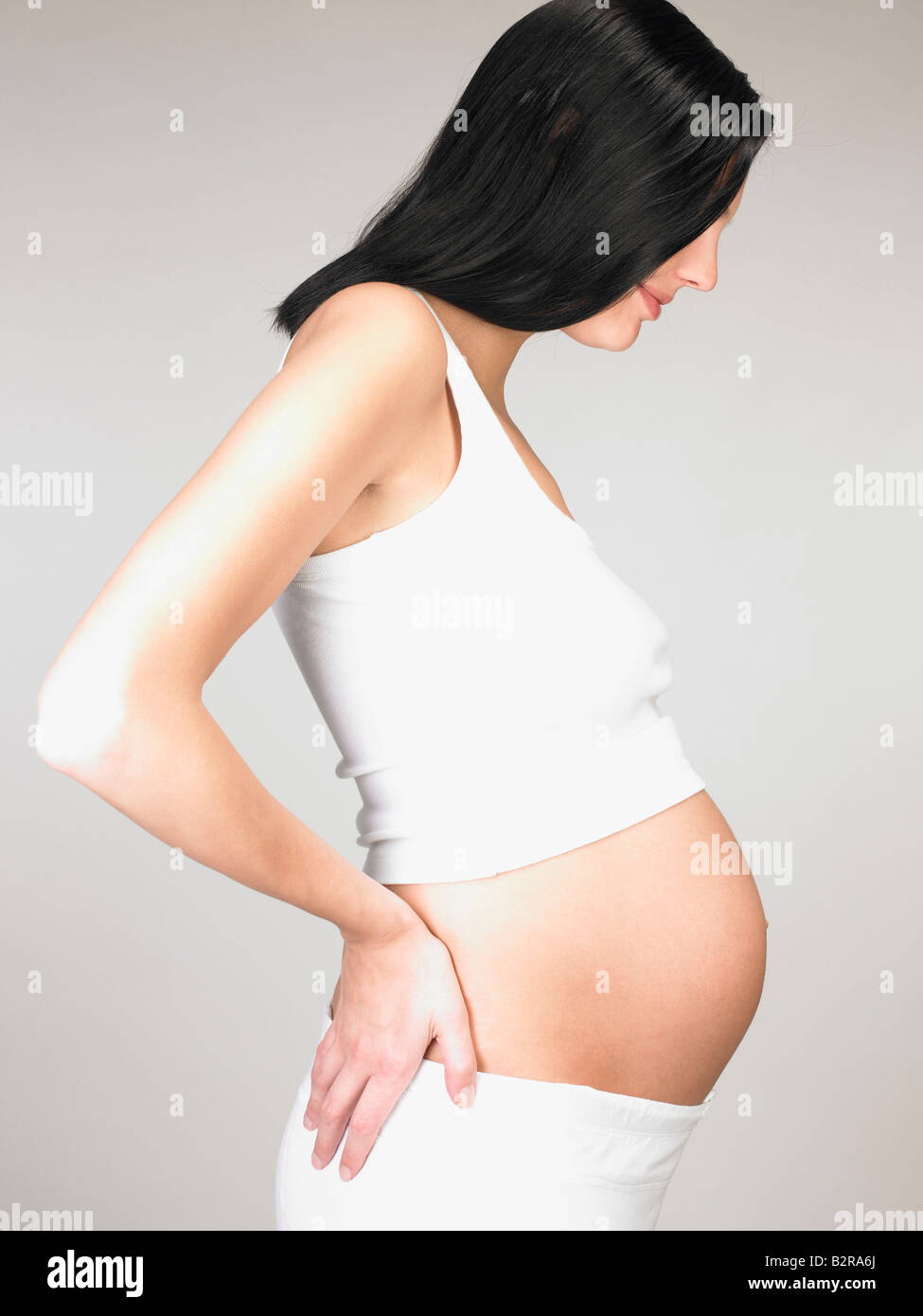 Donna incinta toccando il suo stomaco Foto Stock