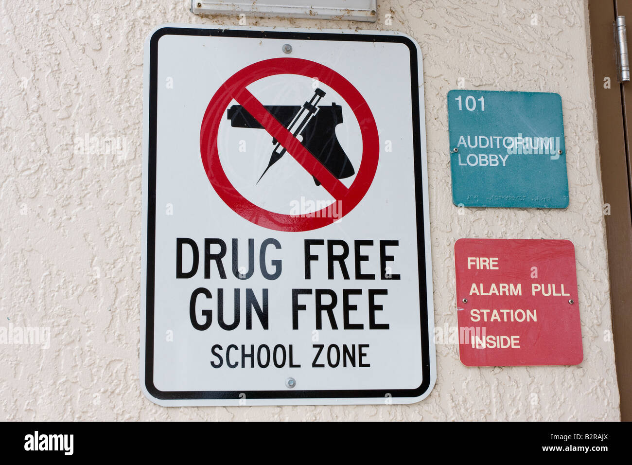 Pistola e Drug Free School zona segno con arma da fuoco e ago in cerchio rosso e Slash sopra pistola Foto Stock