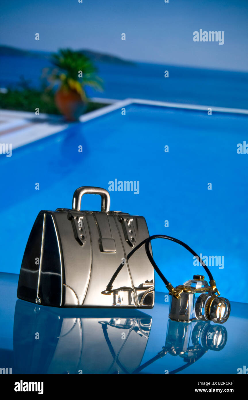 BLING Luxury holiday vacation bling concetto, valigia di argento e cristallo fotocamera con piscina infinity privata e mare in background Foto Stock