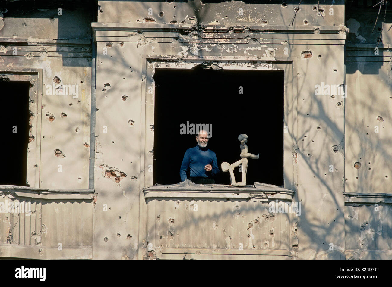 Artisti rumeni VASILE GORDUZ con la sua scultura in piedi dalla finestra del suo studio dopo la rivoluzione di Bucarest 1990 Foto Stock