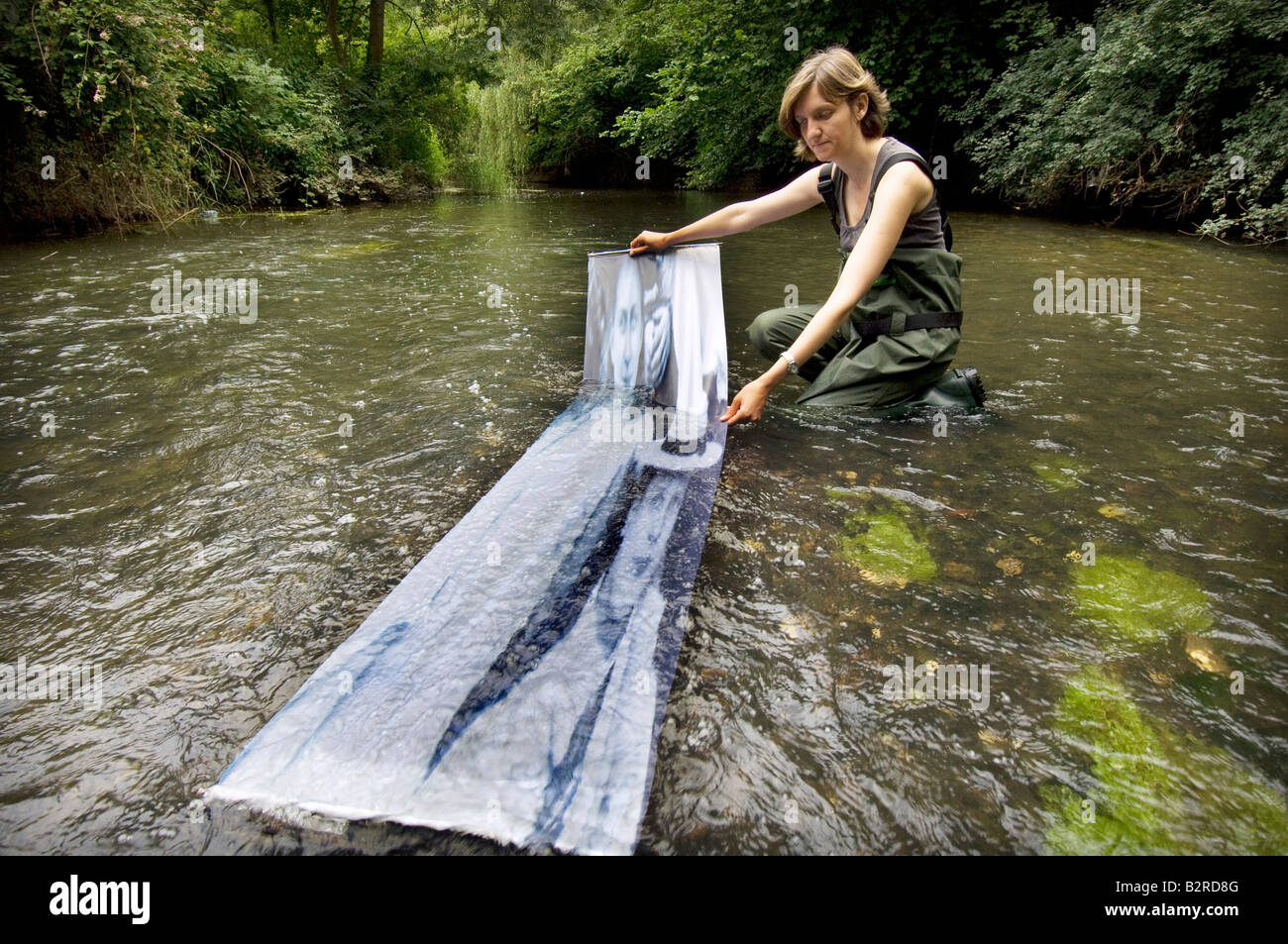 Una donna artista visualizza un ritratto in un fiume Foto Stock