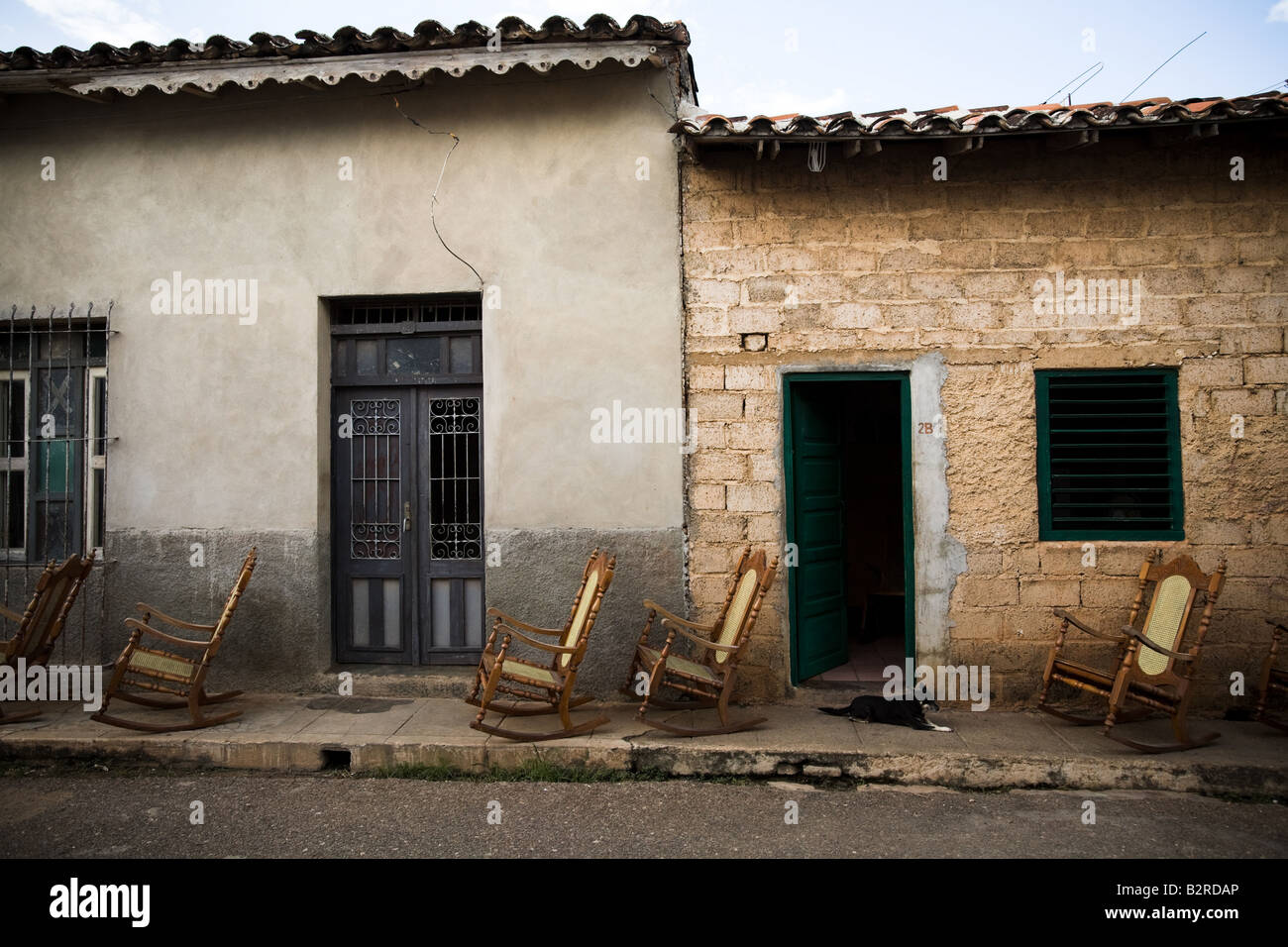 Sedie a dondolo schierate sul marciapiede al di fuori di una casa in Remedios, Cuba Foto Stock
