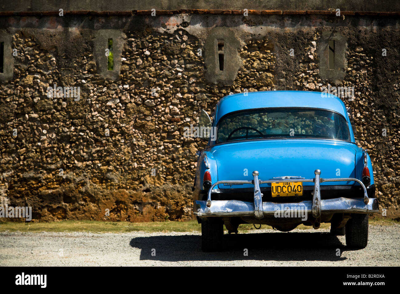 Un degli anni cinquanta era vintage automobile è parcheggiata fuori un forte coloniale in Baracoa, Cuba Foto Stock