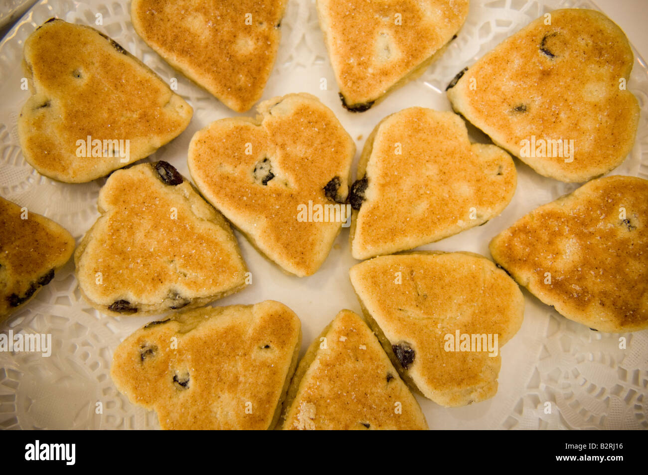 A forma di cuore ad torte gallesi (cannella speziata piastra goccia scones) su una piastra ad un ricevimento di nozze in Galles, Regno Unito Foto Stock