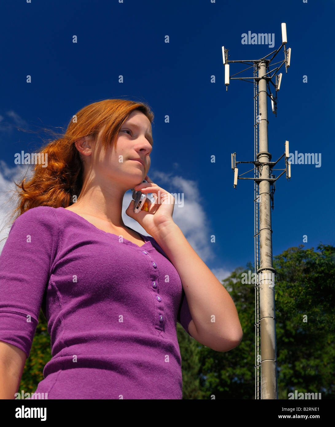 Ragazza adolescente parlando sul suo cellulare a fianco di una torre di comunicazione wireless Toronto Foto Stock