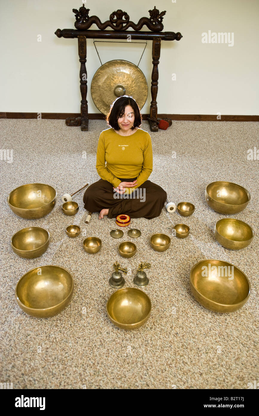 La donna si prepara a suonare le campane tibetane Foto Stock