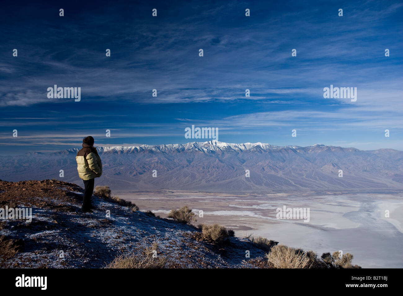 Persona guardando a vista su Badwater, Death Valley verso il Panamint gamma di montagne da Dantes vista. Stati Uniti d'America Foto Stock