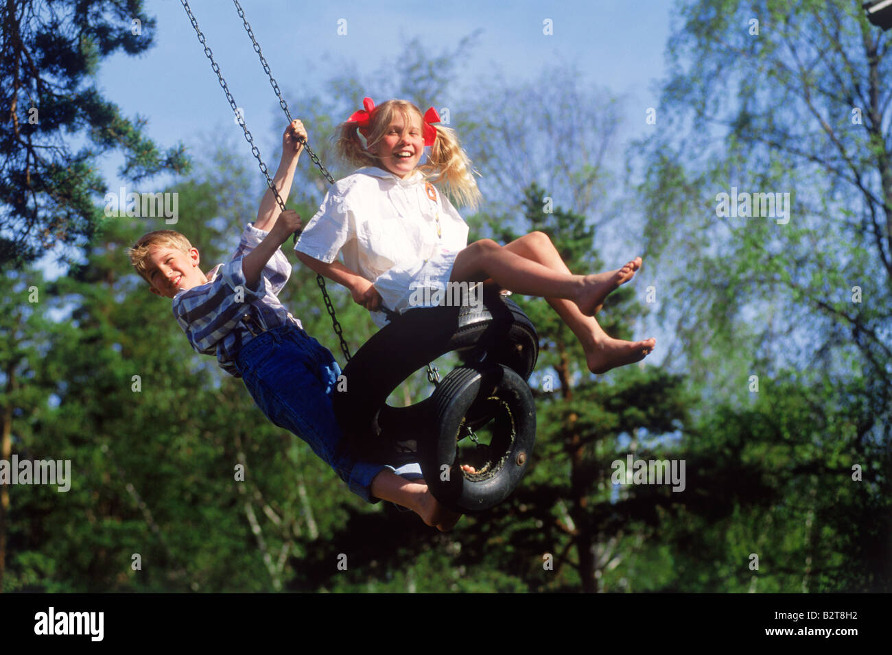 Un ragazzo e una ragazza la condivisione swing sul giorno di estate in Svezia Foto Stock