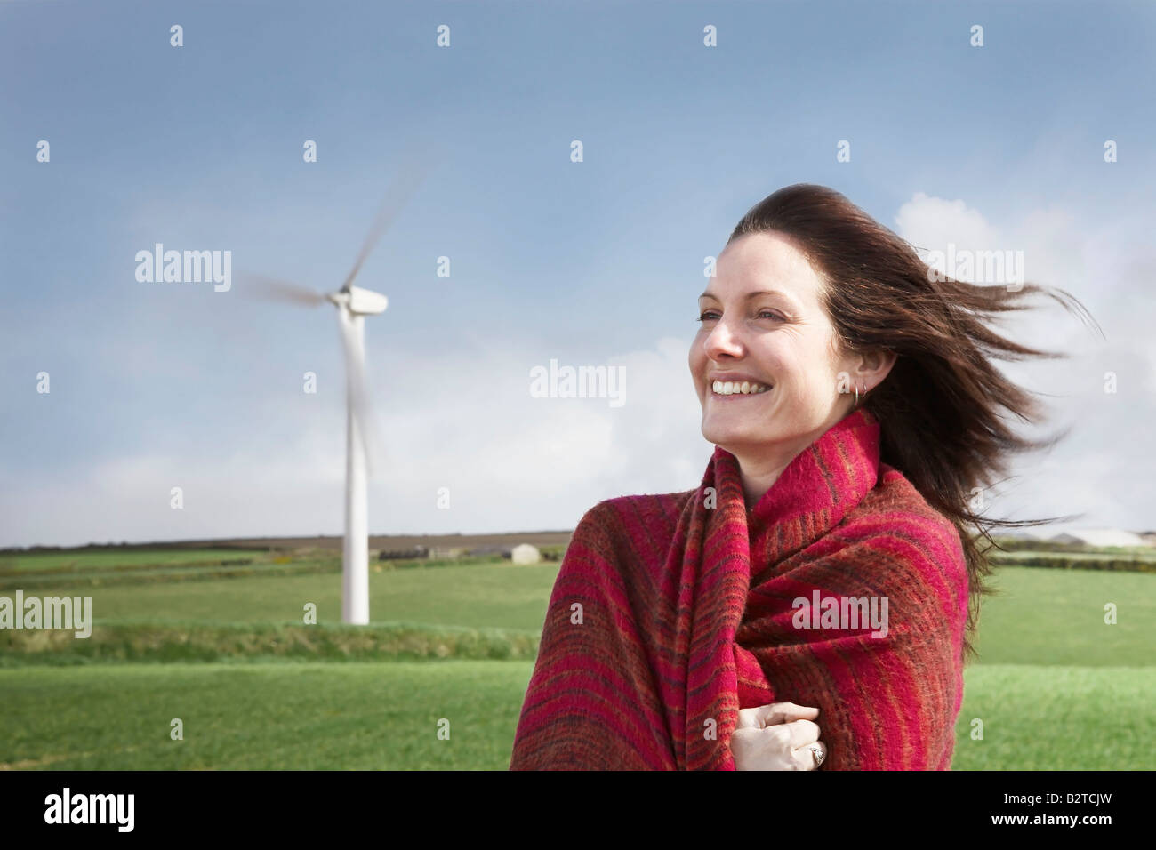 Donna con capelli soffiando su di una centrale eolica Foto Stock