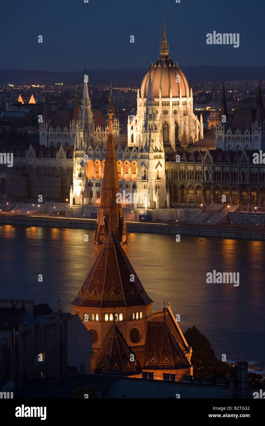 Vista sulla chiesa calvinista e il fiume Danubio al Parlamento illuminata di notte, Pest, Budapest, Ungheria Foto Stock