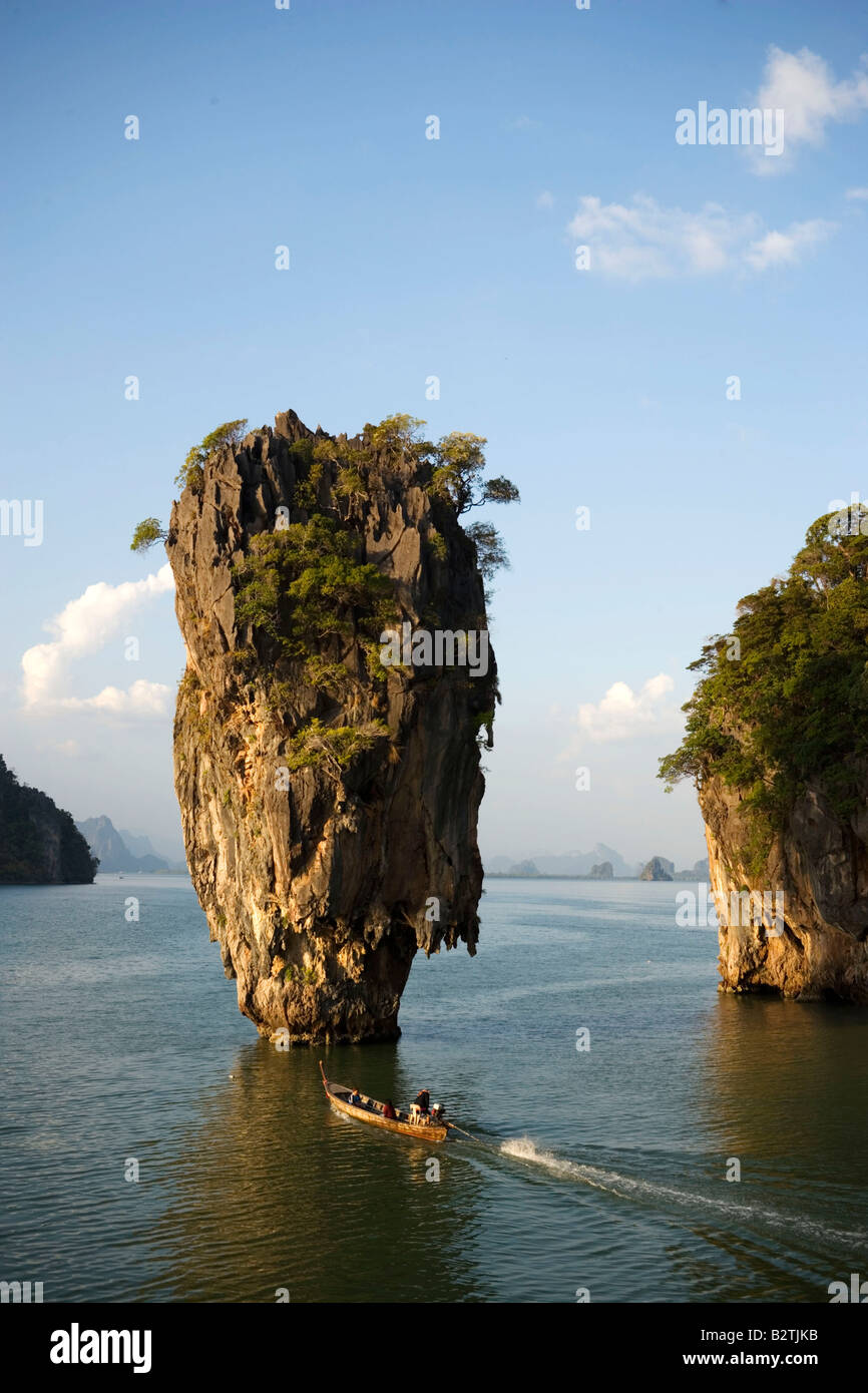 Vista di Koh Tapu, cosiddetta Isola di James Bond, luomo con la pistola dorata, la gente in una longtail boat in primo piano, Ko Khao Phi Foto Stock