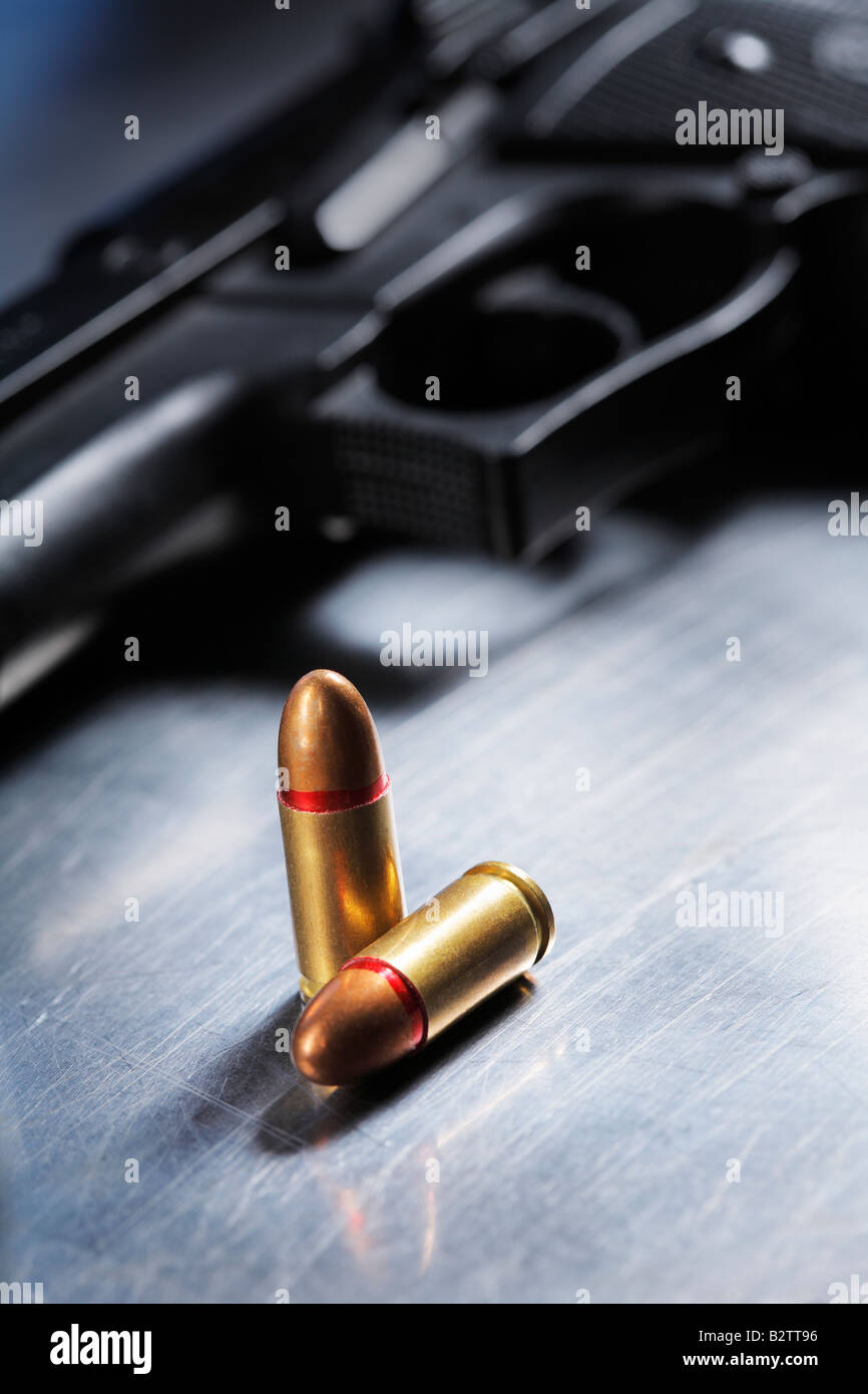 Full Metal Jacket 9 mm parabellum cartucce e una pistola a mano su un graffiato la superficie metallica Foto Stock